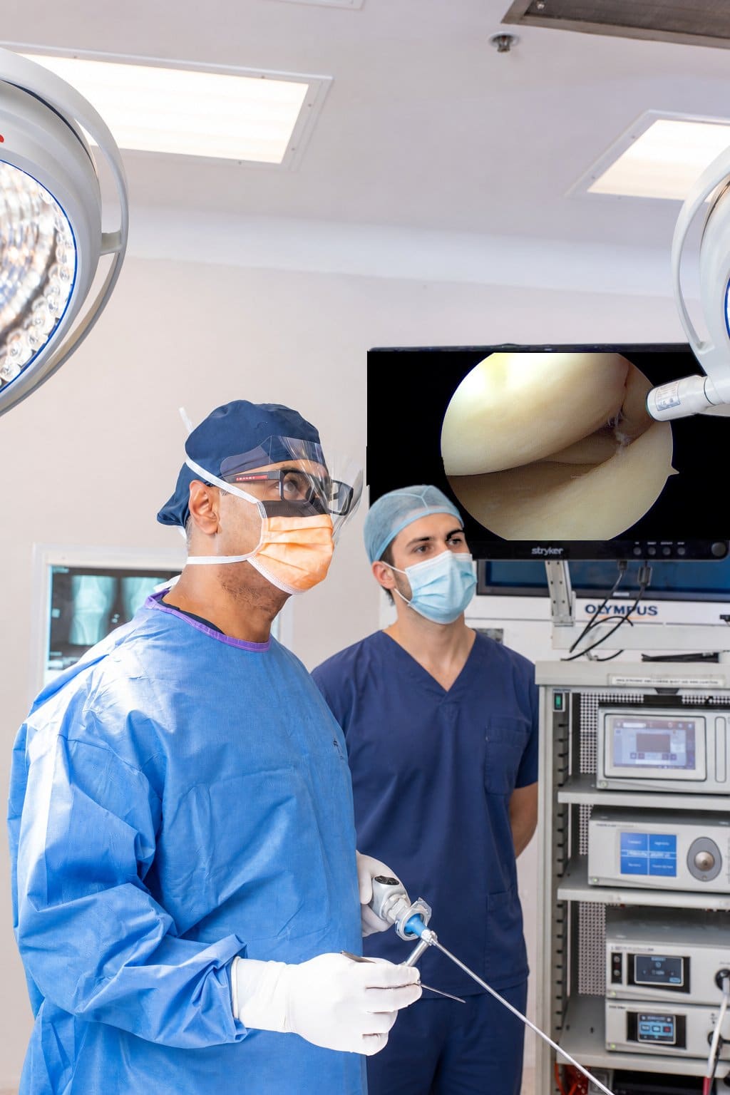 Dr Yas Edirisinghe performing arthroscopic knee surgery in theatre with an observer