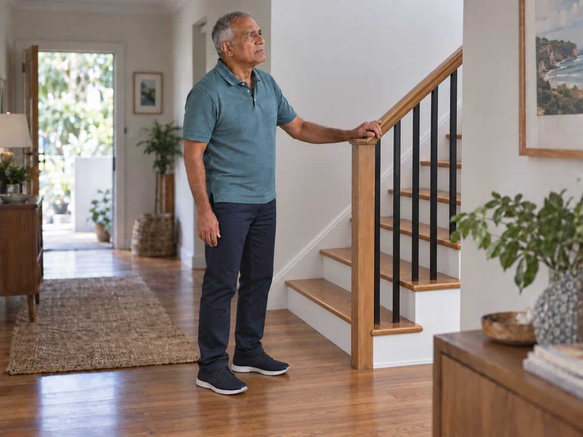 Person pausing on stairs with a hand at the front of the hip